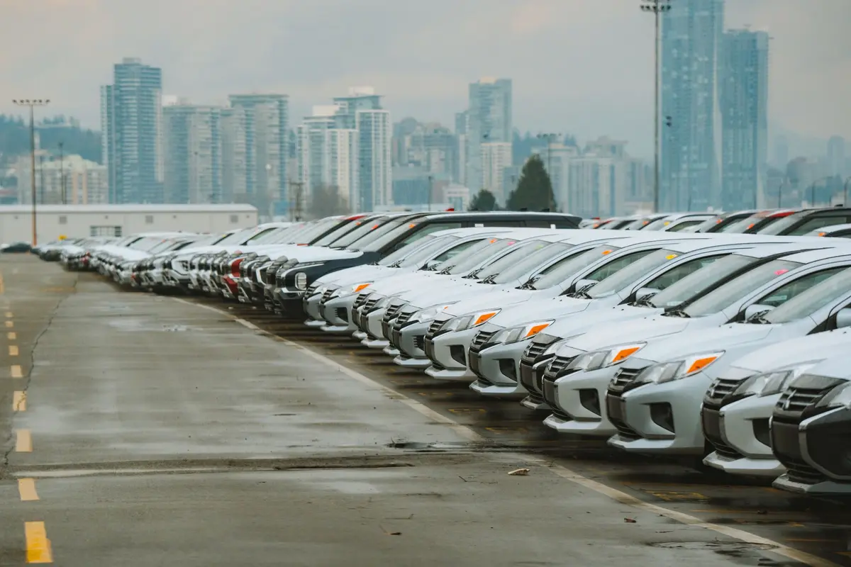 Longa fila de automóveis estacionados num parque de viaturas