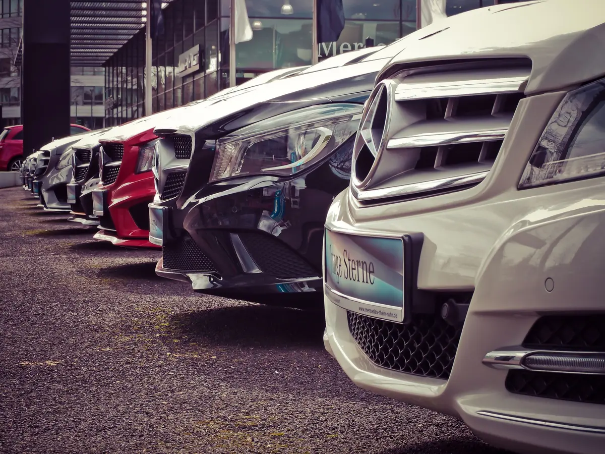 Fila de automóveis ligeiros estacionados num stand ao ar livre